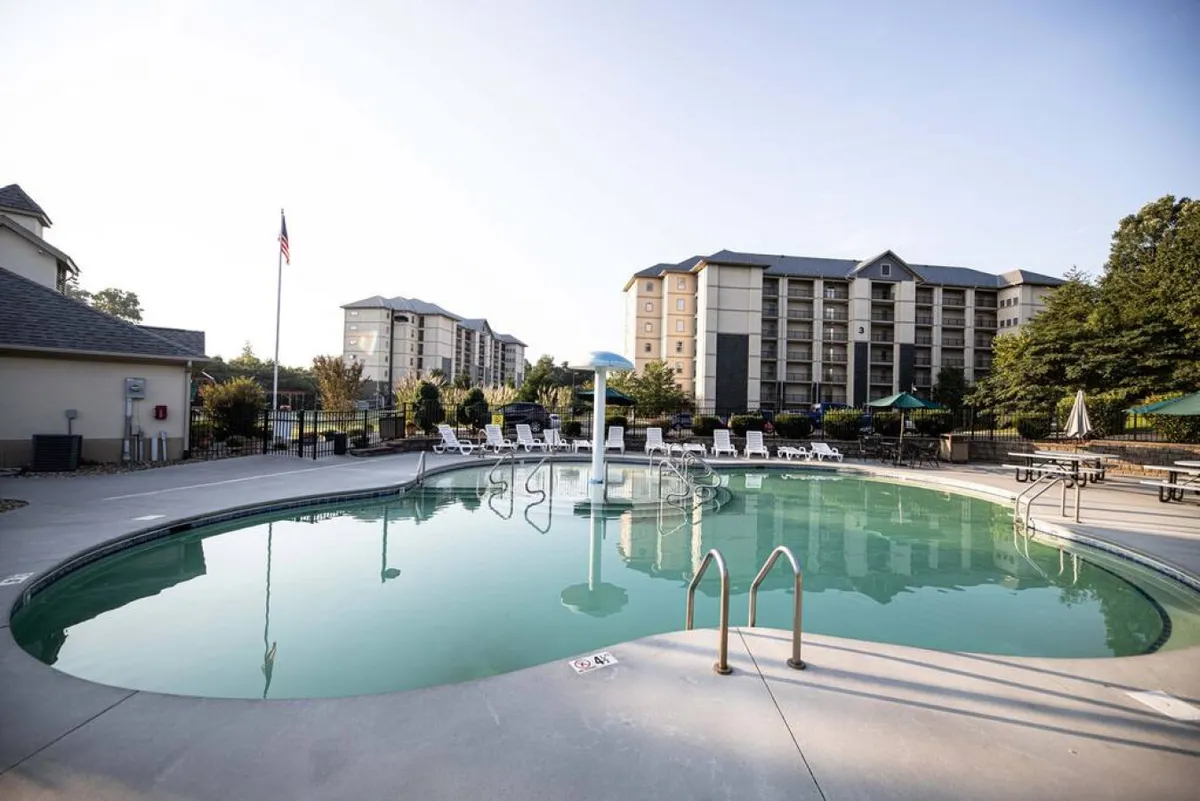 An outdoor swimming pool with a playful water feature and surrounding lounge chairs ideal for sunbathing and social gatherings.