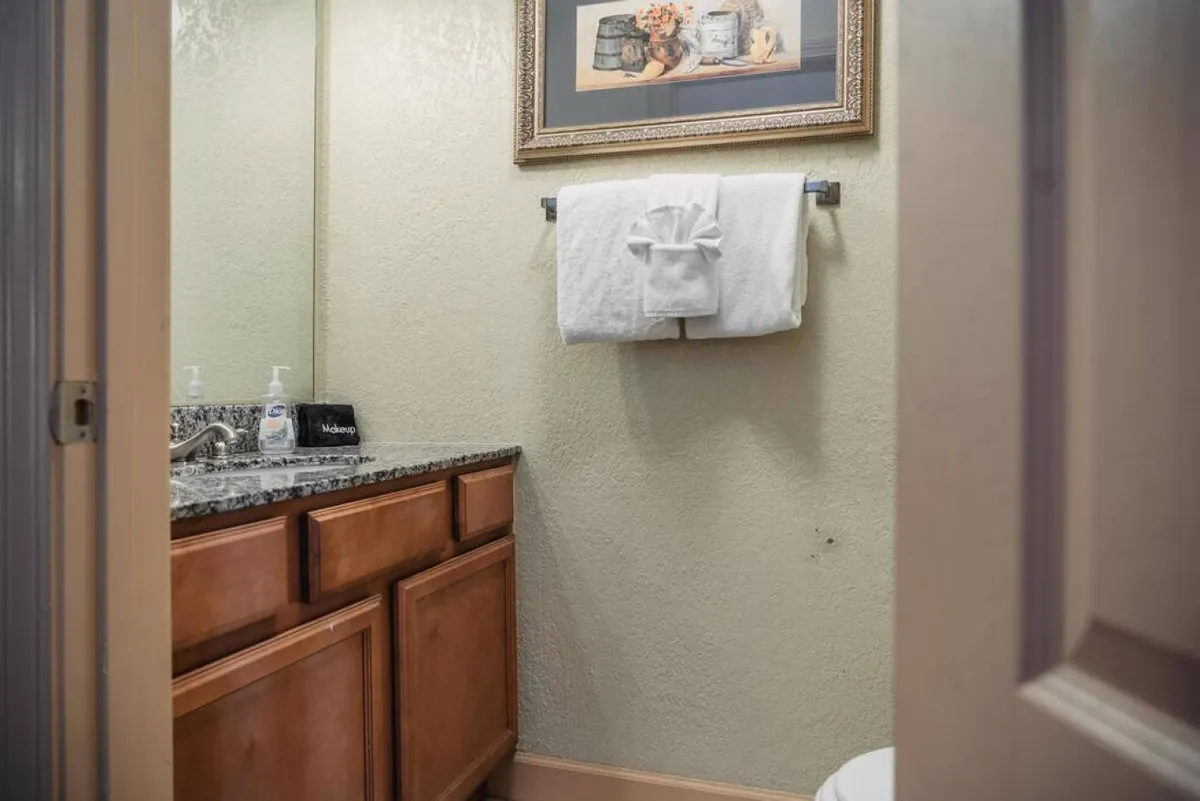 A fresh, inviting bathroom scene with a granite countertop, neatly folded towels, and framed artwork. The space suggests comfort and a refreshing pause after active outdoor pursuits, linking indoor relaxation with outdoor adventure.